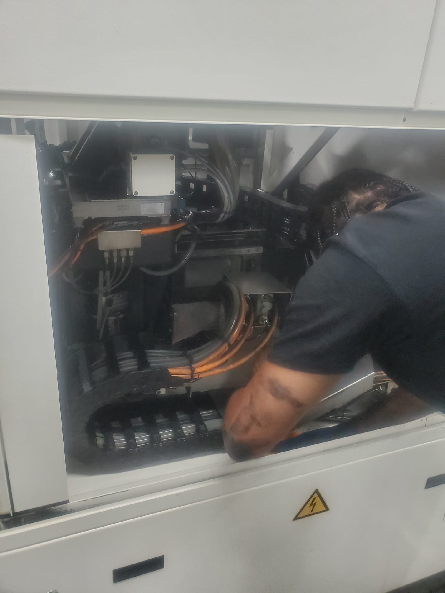 Technician working on machinery internals.